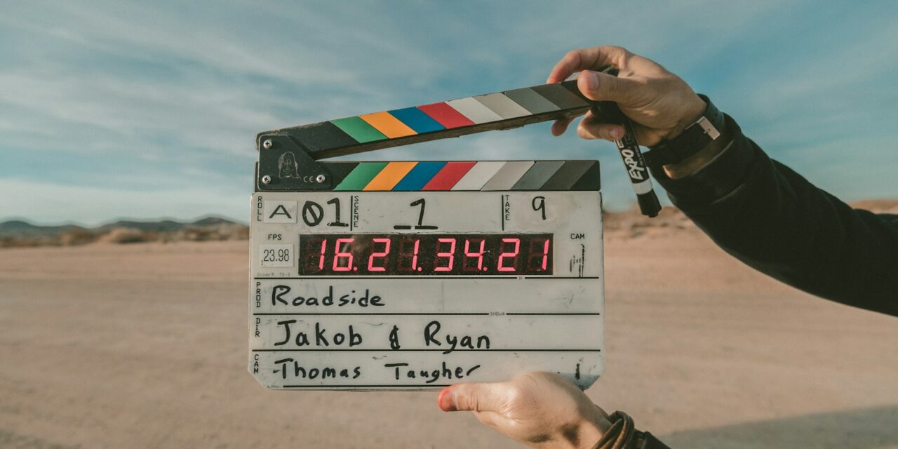 Cameraman cu echipament video compact filmând un documentar pe teren