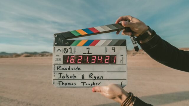 Cameraman cu echipament video compact filmând un documentar pe teren