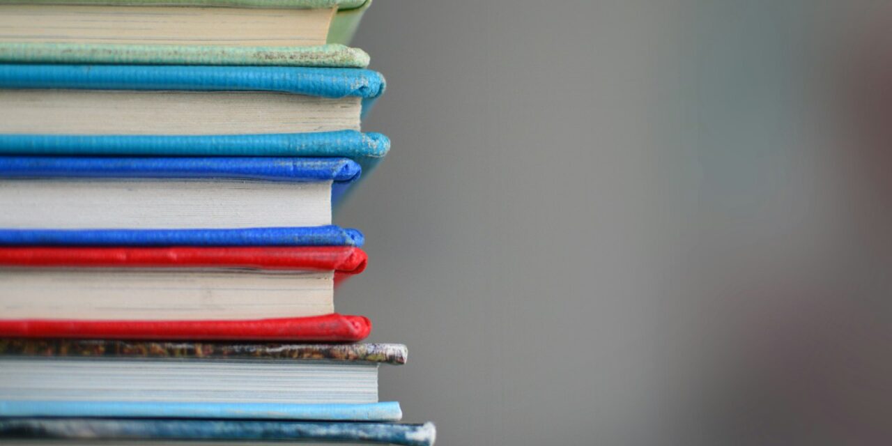 Cărți voluminoase deschise într-o bibliotecă clasică de studiu