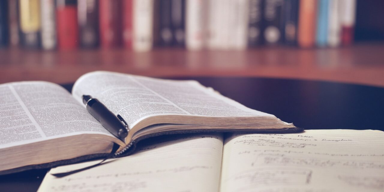 Caiet de notițe plin de adnotări și ochelari de vedere pe birou de studiu