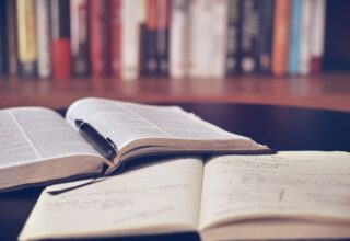 Caiet de notițe plin de adnotări și ochelari de vedere pe birou de studiu