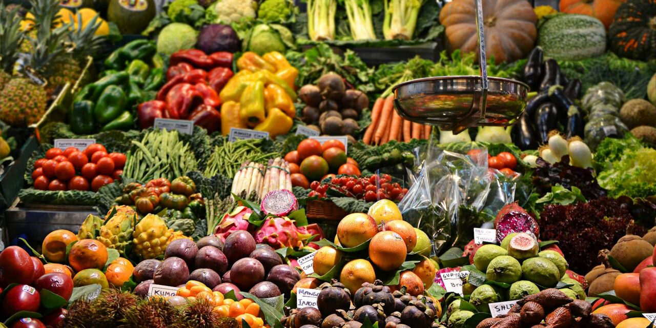 Stand bogat de legume proaspete și fructe într-o piață tradițională vibrantă