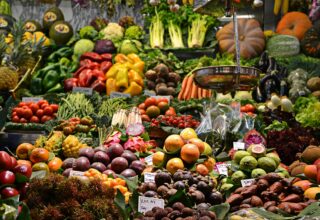 Stand bogat de legume proaspete și fructe într-o piață tradițională vibrantă