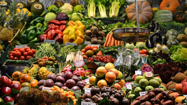 Stand bogat de legume proaspete și fructe într-o piață tradițională vibrantă