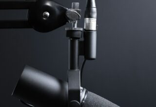 Microfon profesional de studio și gazdă purtând căști over-ear