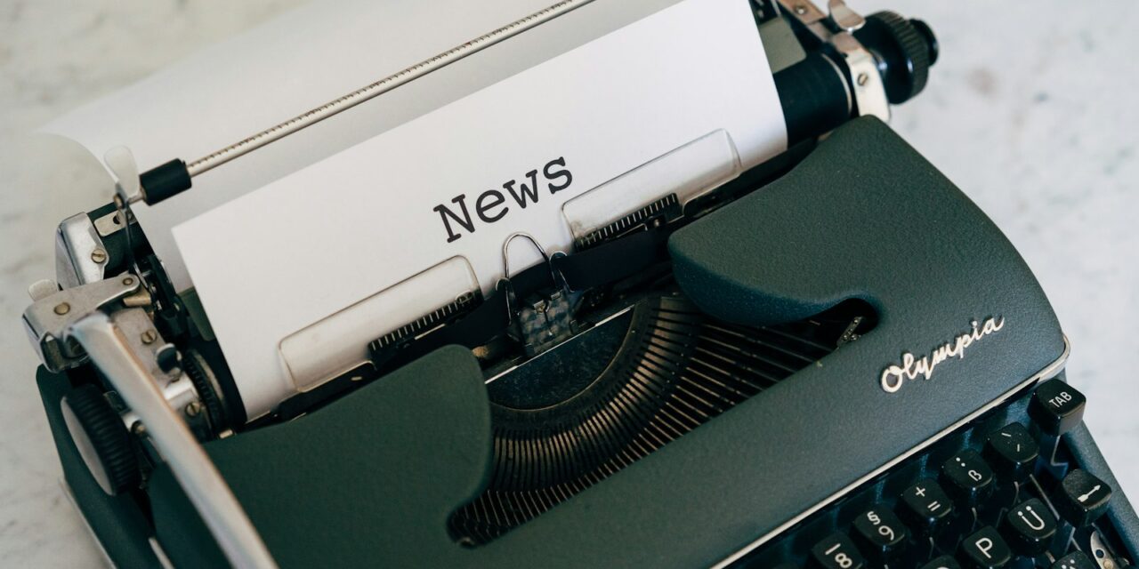 Ziare locale tipărite și jurnaliști discutând la masa redacției
